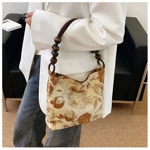 Schicke beige Umhängetasche mit dunklen Blumenmustern und Holzperlengriff-Detail