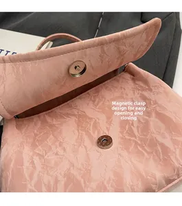 Gros plan sur le fermoir magnétique et la texture plissée du sac cabas rose en PU