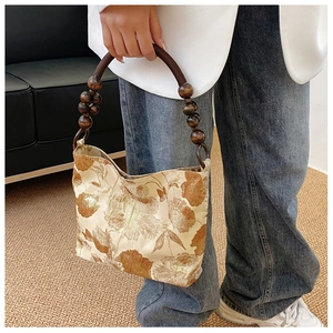 Detail der Seiden-Handtasche mit braunem Jacquard und Perlengriffen aus Holz