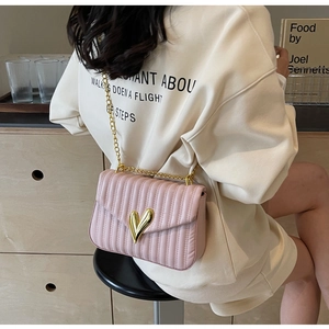 Detailed view of pink quilted PU leather bag with gold heart clasp and chain strap