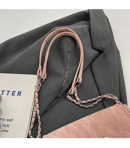 Détail du sac cabas en similicuir rose clair avec texture froissée et bandoulière chaîne