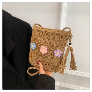 Handmade woven straw crossbody bag with colorful floral decor and long side tassels