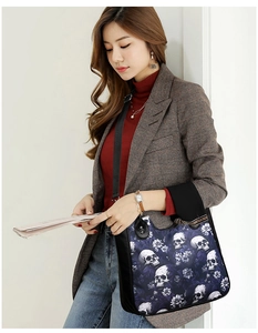 Detailed view of gothic skull floral print on a large capacity tote bag with leather trim