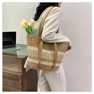 Detail of handwoven brown and white striped straw tote bag showing large storage capacity