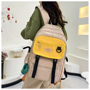 Détail du sac à dos en nylon beige avec poches multiples et fermeture éclair jaune