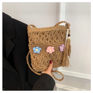 Handmade woven straw crossbody bag with colorful crochet flowers and long side tassel