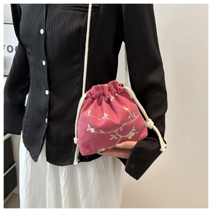 Detail of rose red velvet crossbody bag with white plum blossom embroidery and drawstrings