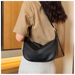 Detail of black textured PU leather hobo bag with silver zipper and slim shoulder strap
