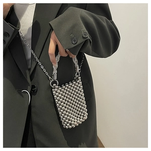 Mini sac à main perlé argenté sur mannequin en blazer vert pour style chic
