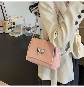 Détail du sac cabas en PU rose avec fermoir papillon argenté et texture plissée