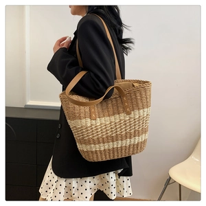 Detail of hand-woven tote bag showing the textured straw pattern and leather shoulder straps
