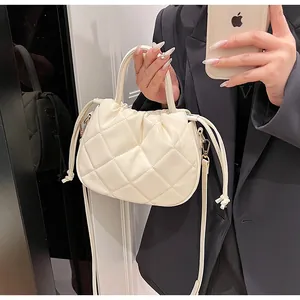 Chic quilted crossbody bag in cream PU leather shown in a mirror selfie for size reference