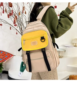 Détail du sac à dos en nylon beige et jaune avec boucles noires et bretelles réglables