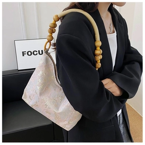 Detailansicht aus rosa Seiden-Jacquard mit elegantem Holzperlen-Geflechtgriff