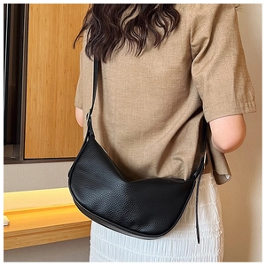 Detail of black crescent hobo bag with pebble texture and adjustable metal buckle