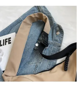 Detail view of khaki nylon bag with adjustable black shoulder strap and buckle
