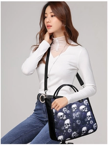 Detailed view of skull floral pattern crossbody bag with detachable strap and black handle