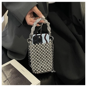 Détail du sac de téléphone en perles argentées avec poignée strass et chaîne métal