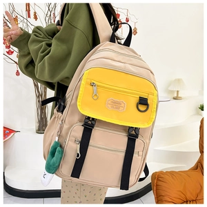 Détail du sac à dos en nylon bicolore avec poches zippées et joli pendentif en peluche