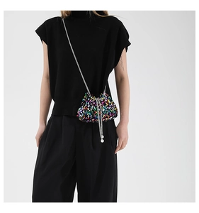Detail view of multicolored sequin bucket bag featuring a pearl drawstring and silver chain