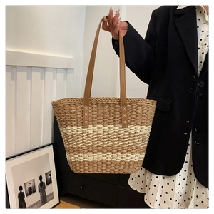 Detailed view of the woven tote bag featuring brown and white stripes and leather handles