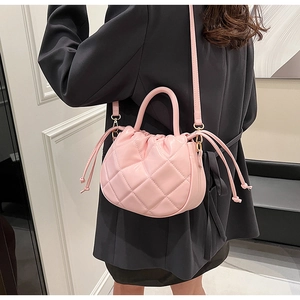 Pink quilted PU leather crossbody bag with drawstring handle shown on a model suit