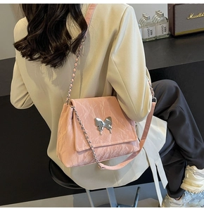 Détails du sac bandoulière rose avec texture plissée et boucle papillon argent