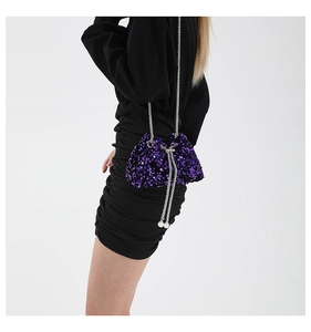 Close-up of purple sequined bucket bag with silver chain strap and pearl drawstring detail