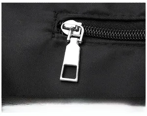 Detailed macro view of high-quality silver rectangular metal zipper on a black fabric bag