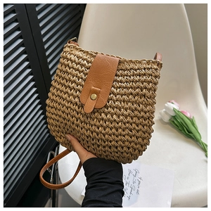 Fashionable woven straw shoulder bag with dark brown leather flap and brass snap button