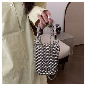 Détail du sac seau à perles argentées avec poignée en métal torsadé et chaîne fine