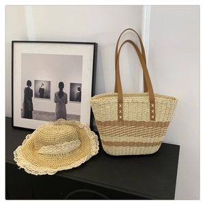 Detail of hand-woven tote bag with leather handles and matching lace-trimmed straw hat
