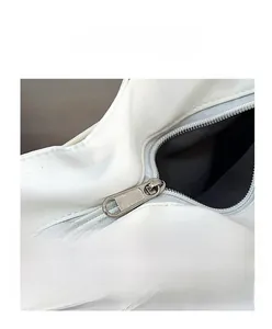 Dettaglio della cerniera in metallo argento sulla borsa tote bianca stile minimalista