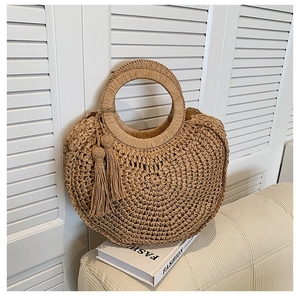 Chic natural woven straw handbag with ring handle and tassels for summer beach vacation