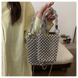 Détail du sac à main perlé argenté avec poignée en strass et chaîne en métal