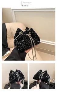 Detail of black sequined bucket bag featuring silver chain strap and pearl accents