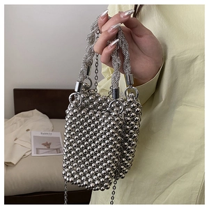 Détail d'un mini sac à perles métalliques argentées avec texture tissée et bandoulière