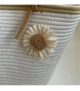 Close-up of woven white cotton rope tote bag with 3D daisy flower and leather handles
