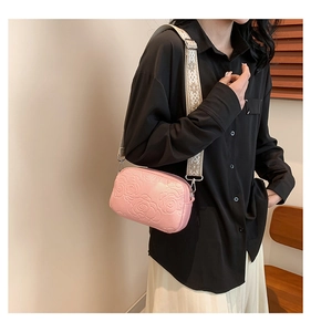 Detail of rose embossed pink PU crossbody bag with printed wide shoulder strap for women