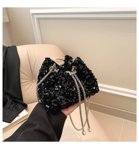 Detail of black sequined bucket bag with silver chain strap and pearl drawstring tassels