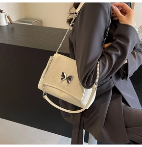 Détail du sac cabas en PU crème avec boucle papillon élégante en métal foncé