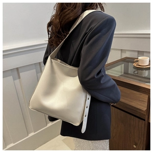 Chic beige PU leather crossbody bag worn by model in a stylish professional setting