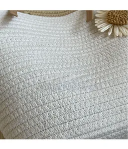 Close-up of white woven straw bag texture with a daisy flower charm and brown handle