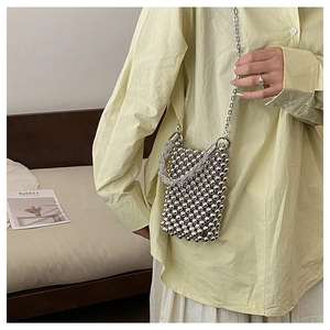 Détail d'un petit sac à bandoulière en perles argentées avec fine chaîne métallique