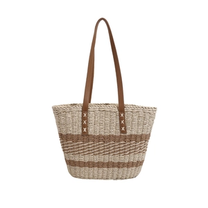 Summer woven straw tote bag with brown leather handles and striped texture