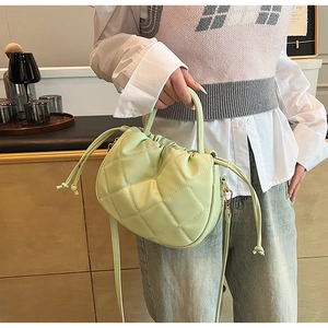 Close-up of light green quilted PU leather cloud bag with drawstring and texture details