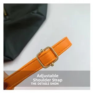 Detail view of adjustable orange leather strap with golden square buckle and fine stitching