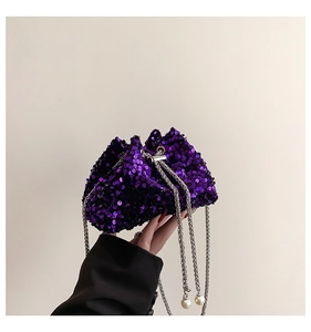 Detail of purple sequin bucket bag with silver chain strap and decorative pearls