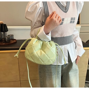 Detail of light green quilted PU leather handbag with adjustable crossbody strap
