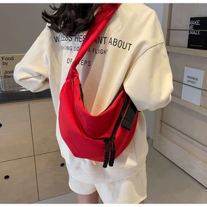 Detail of red crescent crossbody bag with large capacity and woven zipper pulls